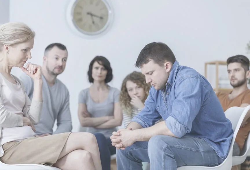 Группа людей слушает мужчину